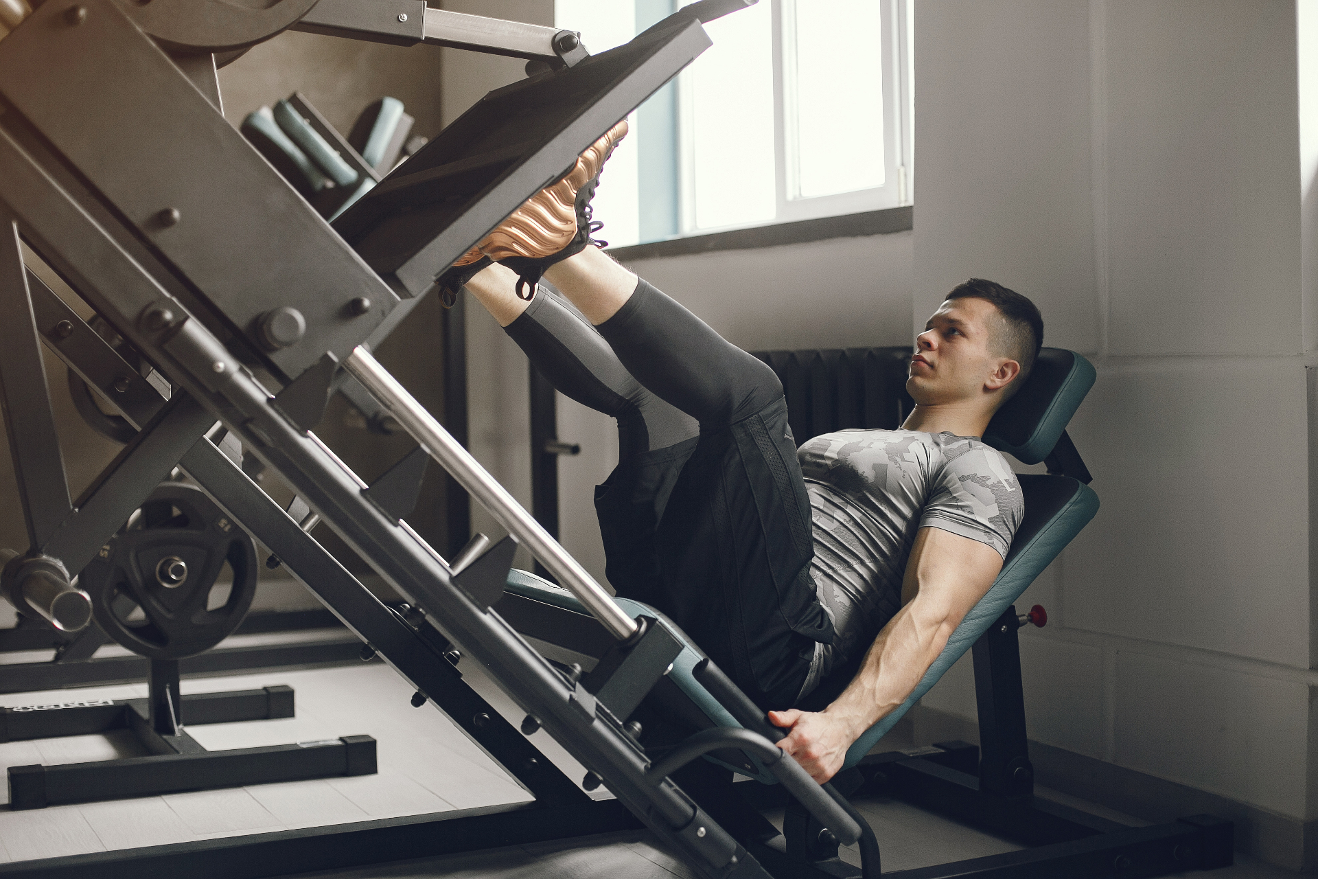 Hombre entrenando prensa de pierna en el gimnasio